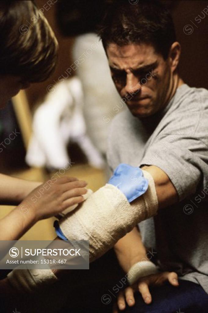 Stock Photo: 1531R-467 Close-up of a person dressing a man's injured hand