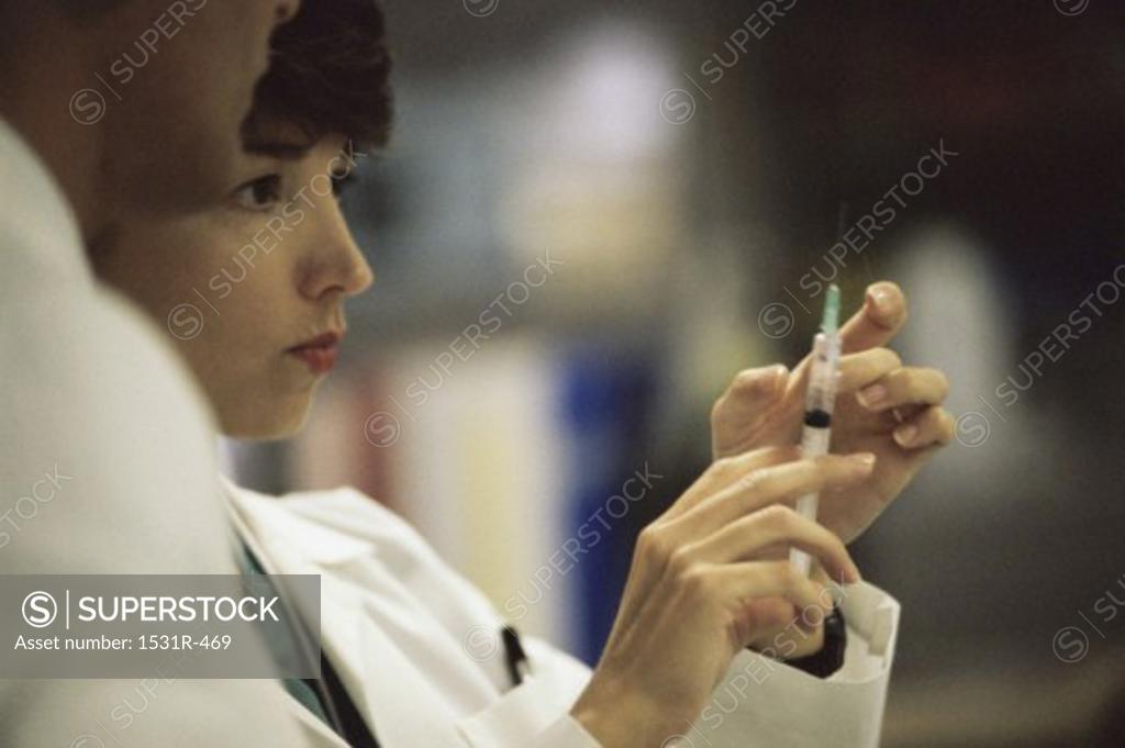 Stock Photo: 1531R-469 Female doctor holding a syringe
