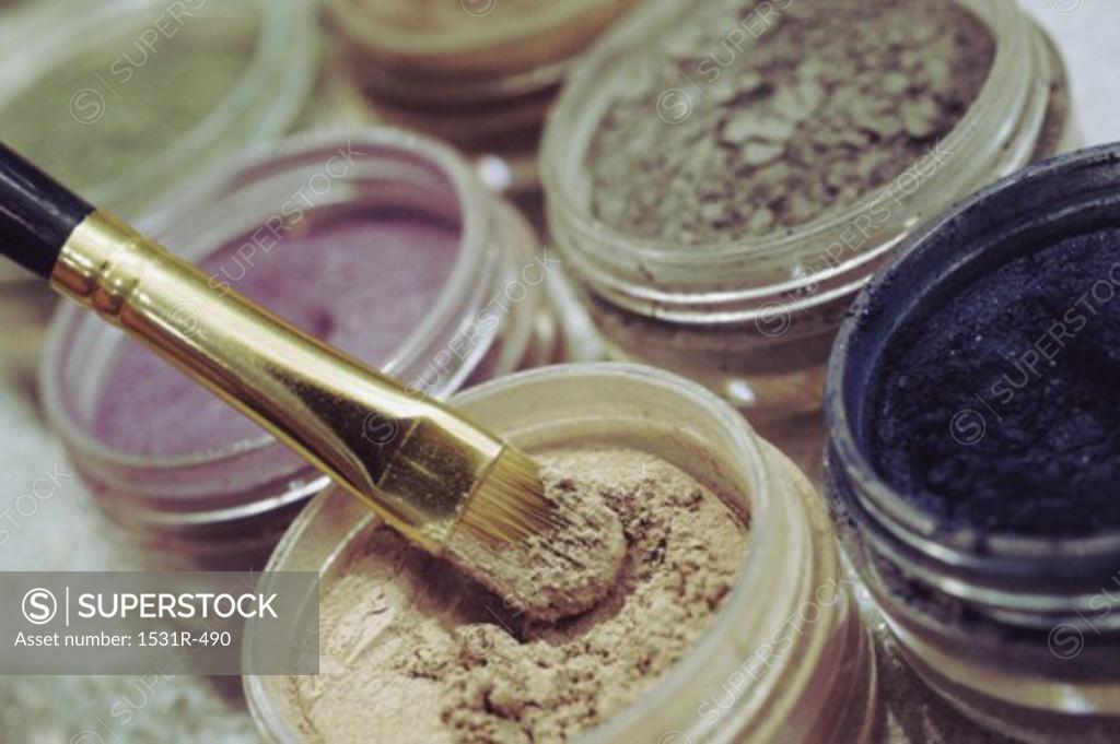 Stock Photo: 1531R-490 Close-up of open containers of cosmetics and an applicator brush