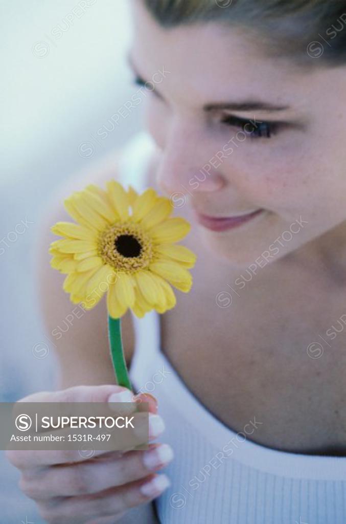 Stock Photo: 1531R-497 Young woman smelling a flower