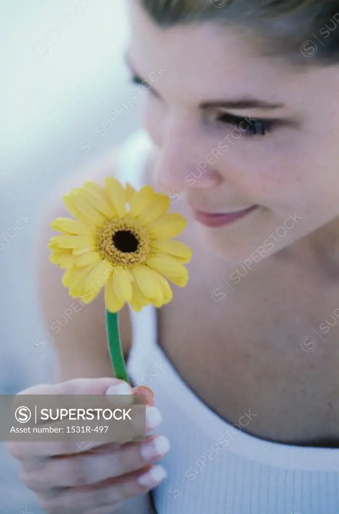 Young woman smelling a flower