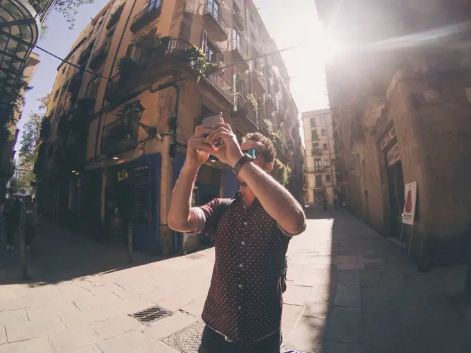 young tourist man taking pictures in Barcelona