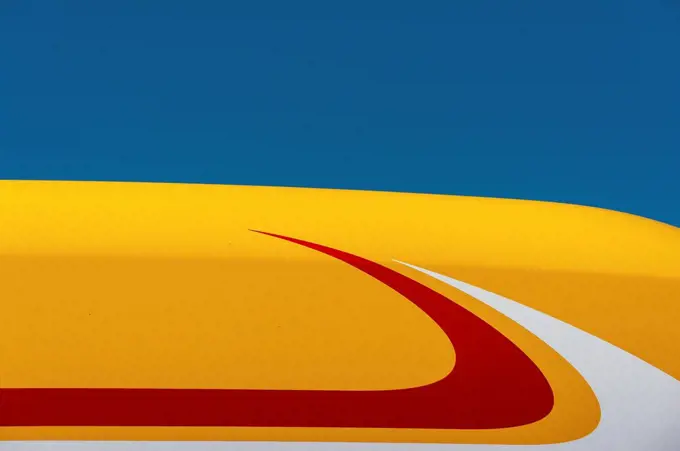 Blue sky and yellow, white, and red roof of truck, England
