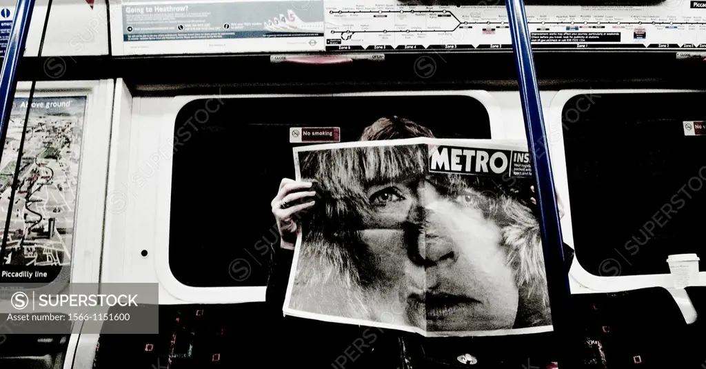 Reading the newspaper inside a subway car