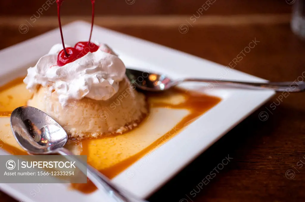A flan dessert on a plate in a restaurant.