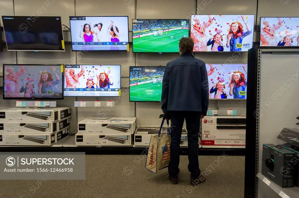 A customer browses large screen televisions in a Best Buy electronics store in Union Square in New York