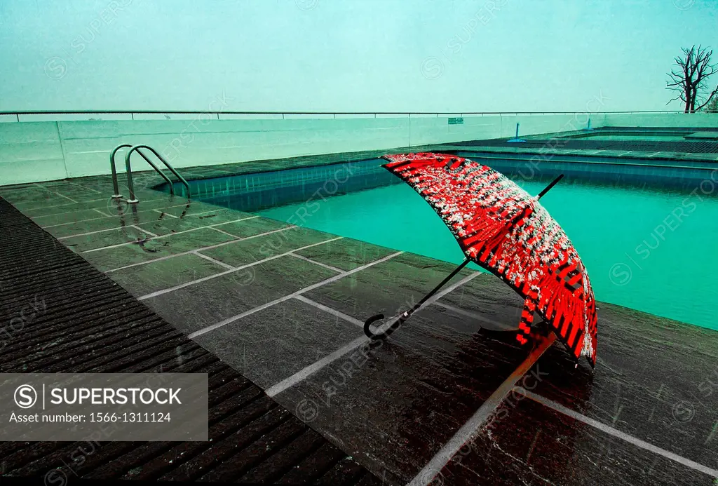 Red umbrella covered with snow at poolside, after season symbol, Geneva, Switzerland, snow fall