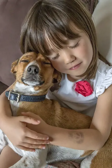 A toddler girl and her pet with closed eyes.