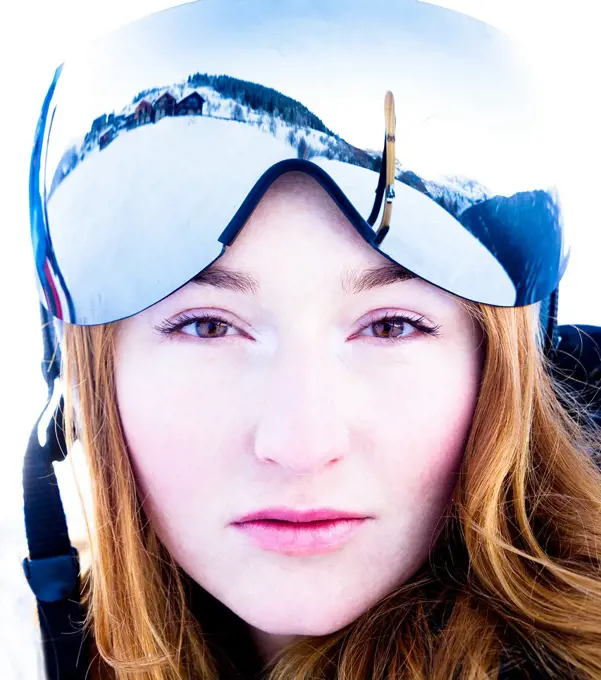 Ginger young woman wearing ski glasses in the Alps.