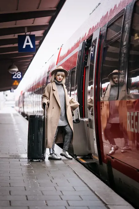 Fashion blogger Esra Eren aka @nachgestern stepping into regional train, travelling. At Munich central station, Germany.