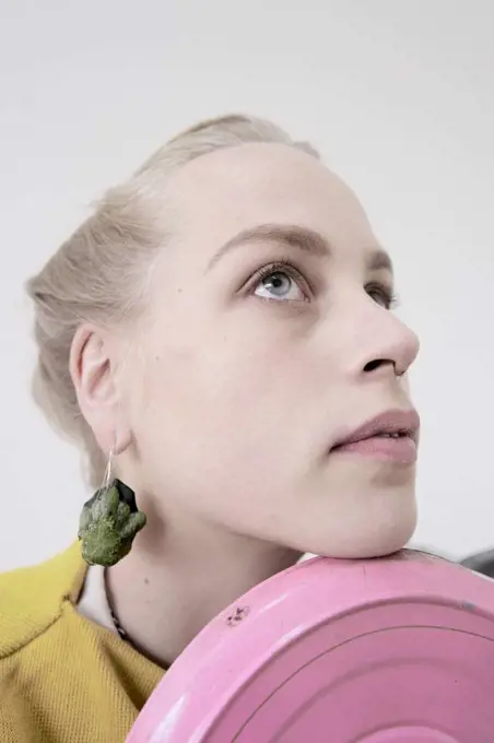 young woman wearing earrings made of raw zucchini