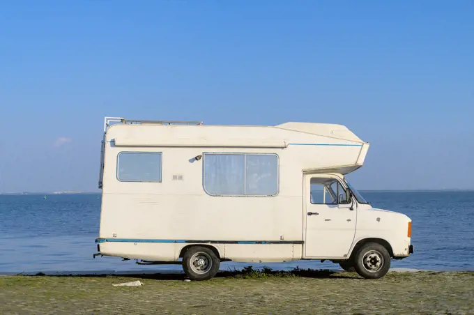 Vintage camper van parked by the riverfront.