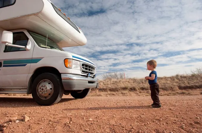 Toddler standing in front of motor home