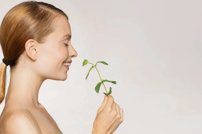 Young woman enjoying fragrence of fresh mint leaves