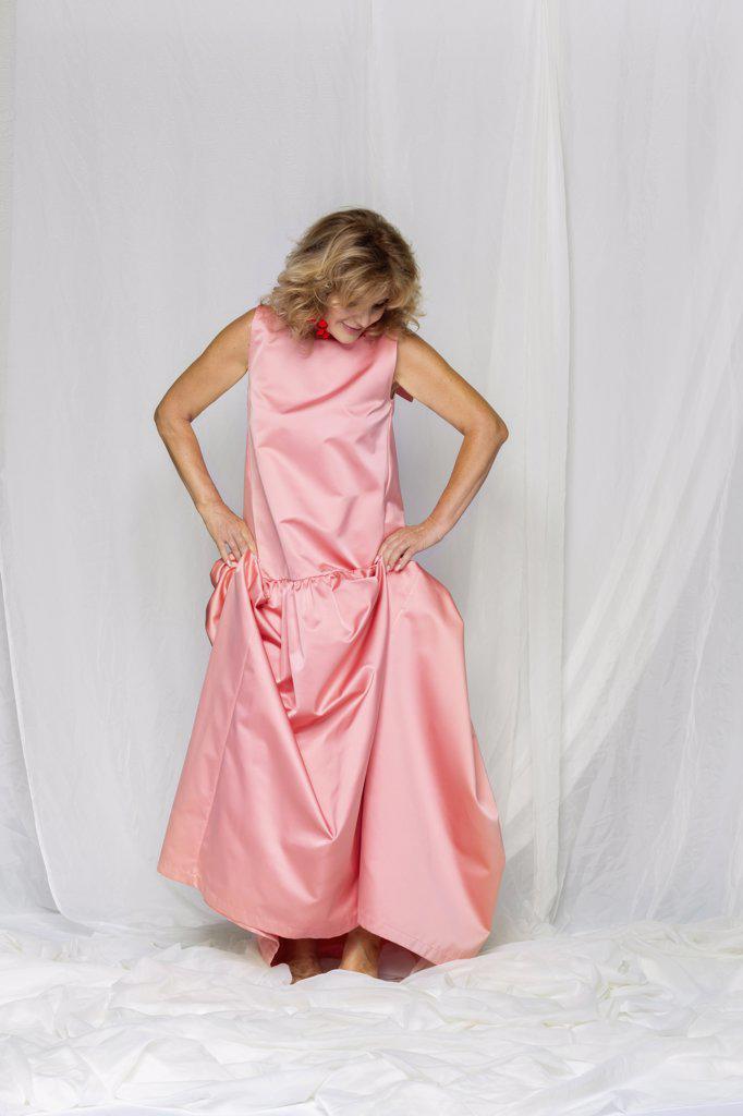 Woman in pink satin dress looking down