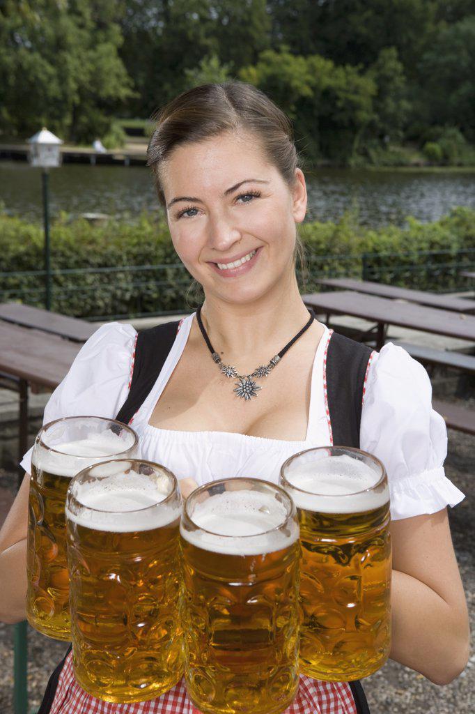 A traditionally clothed German woman serving beer in a beer garden