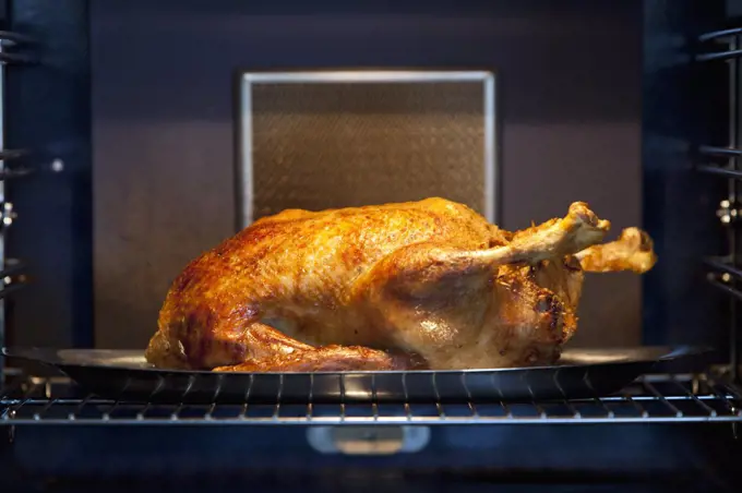 A chicken roasting in an oven