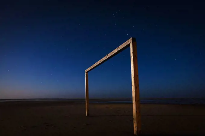 Soccer goal on beach at night