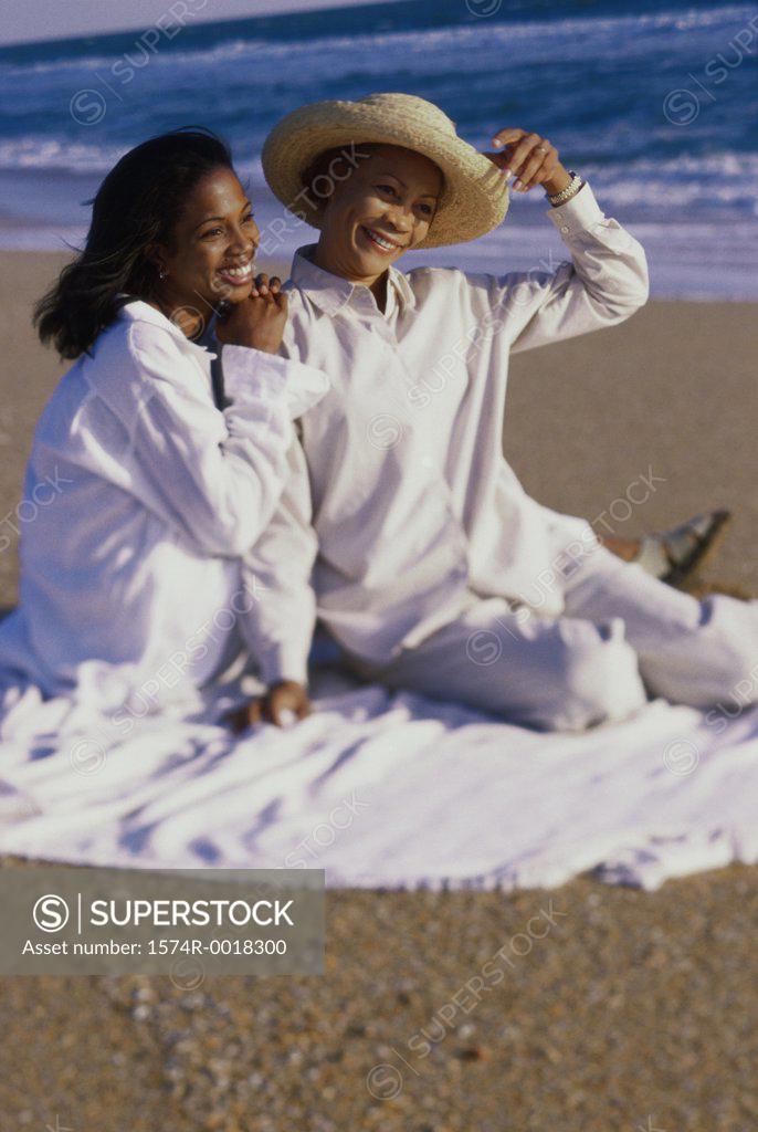 Stock Photo: 1574R-0018300 Mother sitting with her daughter on the beach