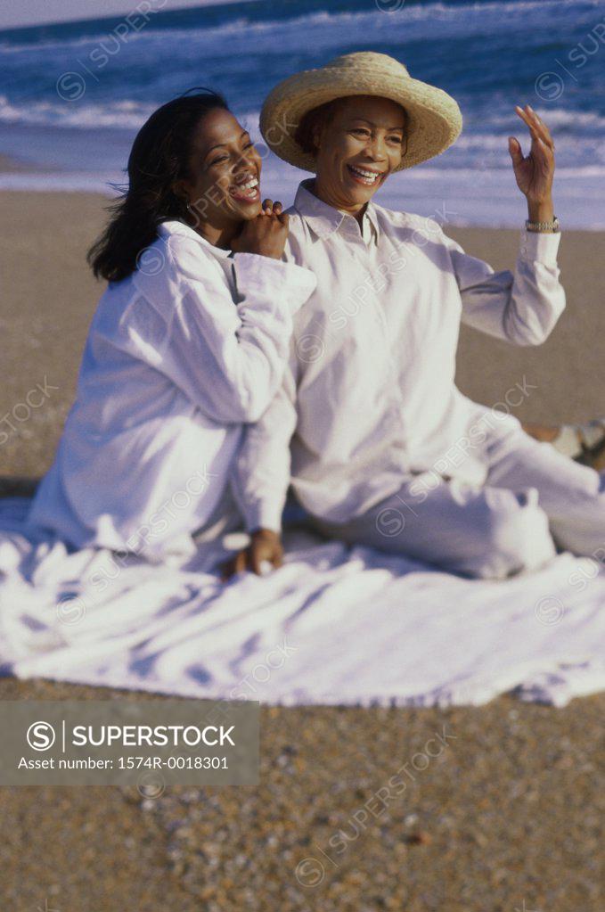 Stock Photo: 1574R-0018301 Mother sitting with her daughter on the beach