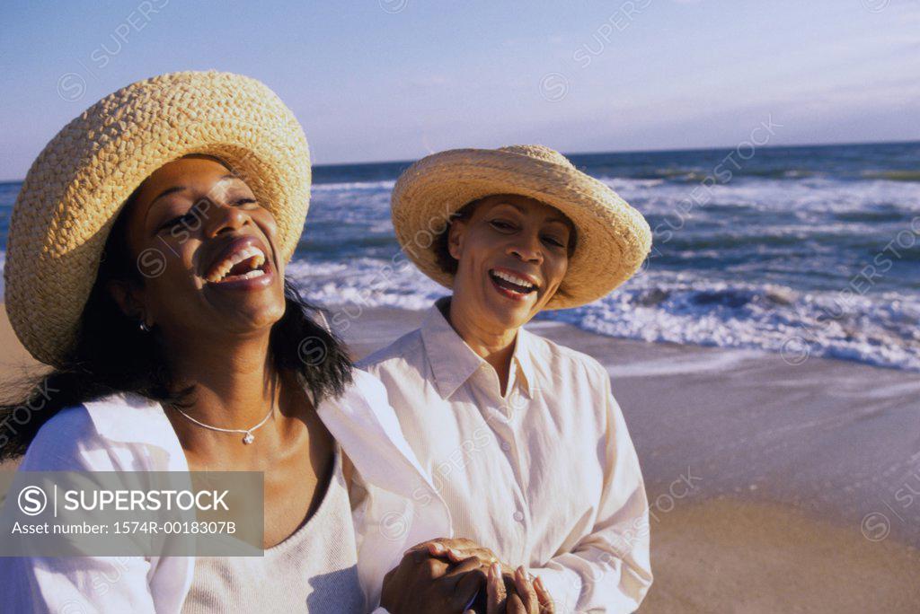Stock Photo: 1574R-0018307B Mother laughing with her daughter on the beach