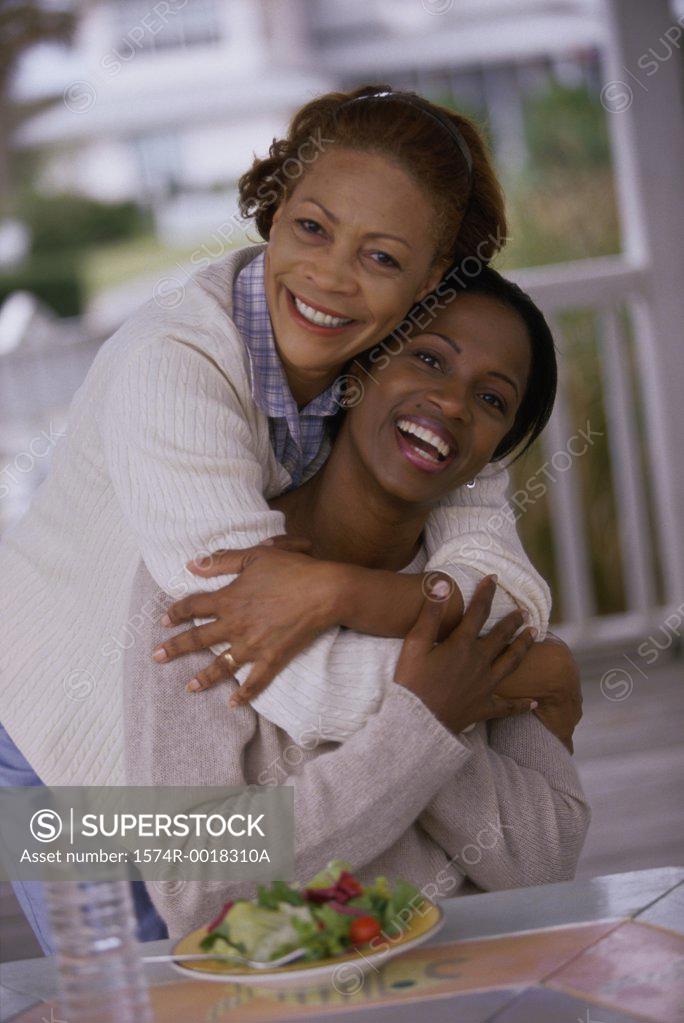 Stock Photo: 1574R-0018310A Portrait of a mother hugging her daughter on the porch