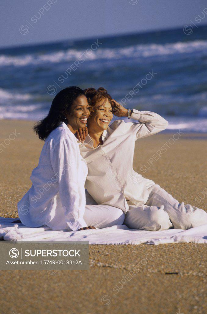 Stock Photo: 1574R-0018312A Mother and daughter sitting on the beach