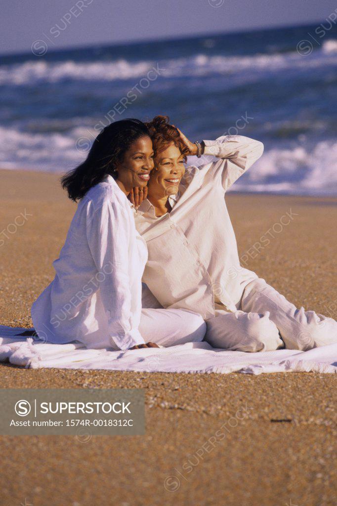 Stock Photo: 1574R-0018312C Mother and daughter sitting on the beach