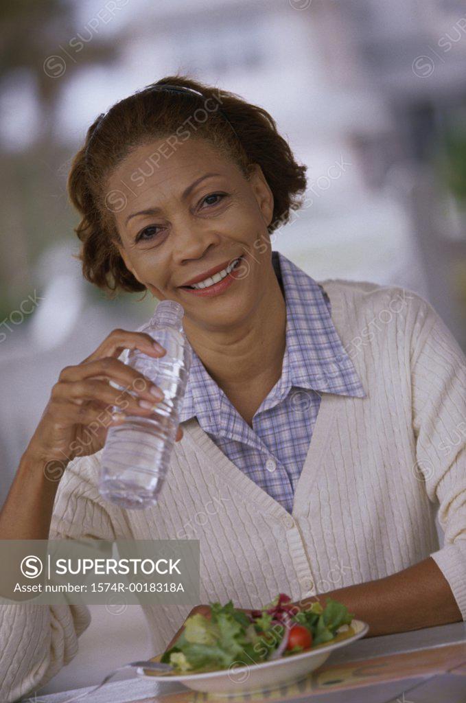 Stock Photo: 1574R-0018318A Portrait of a mature woman drinking water from a water bottle