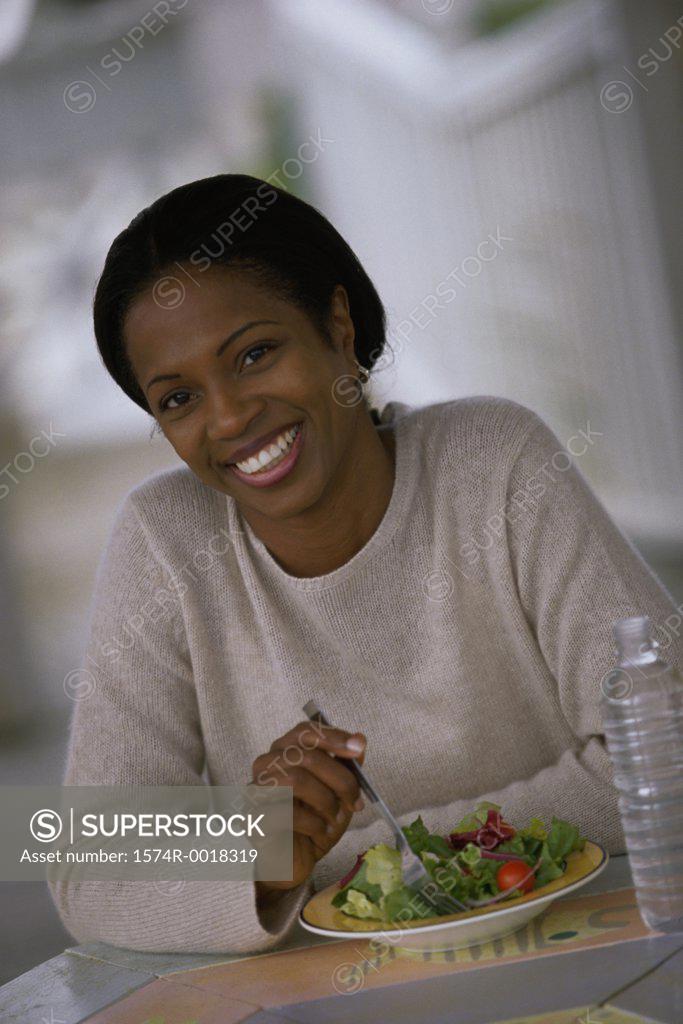 Stock Photo: 1574R-0018319 Portrait of a young woman with a plate of salad