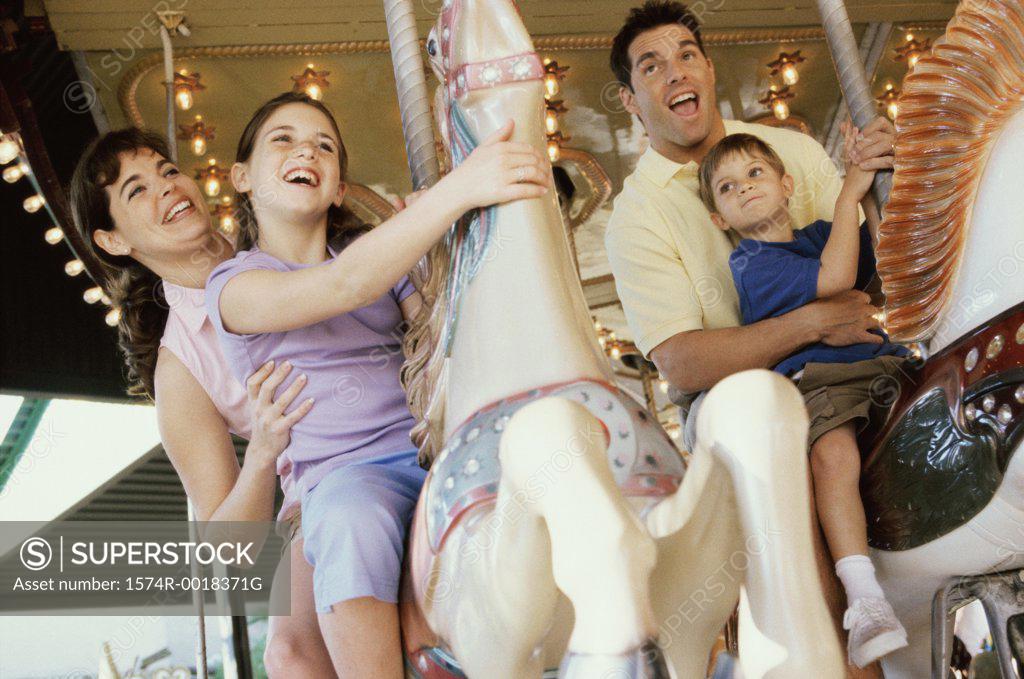 Stock Photo: 1574R-0018371G Low angle view of parents with their son and daughter on a carousel