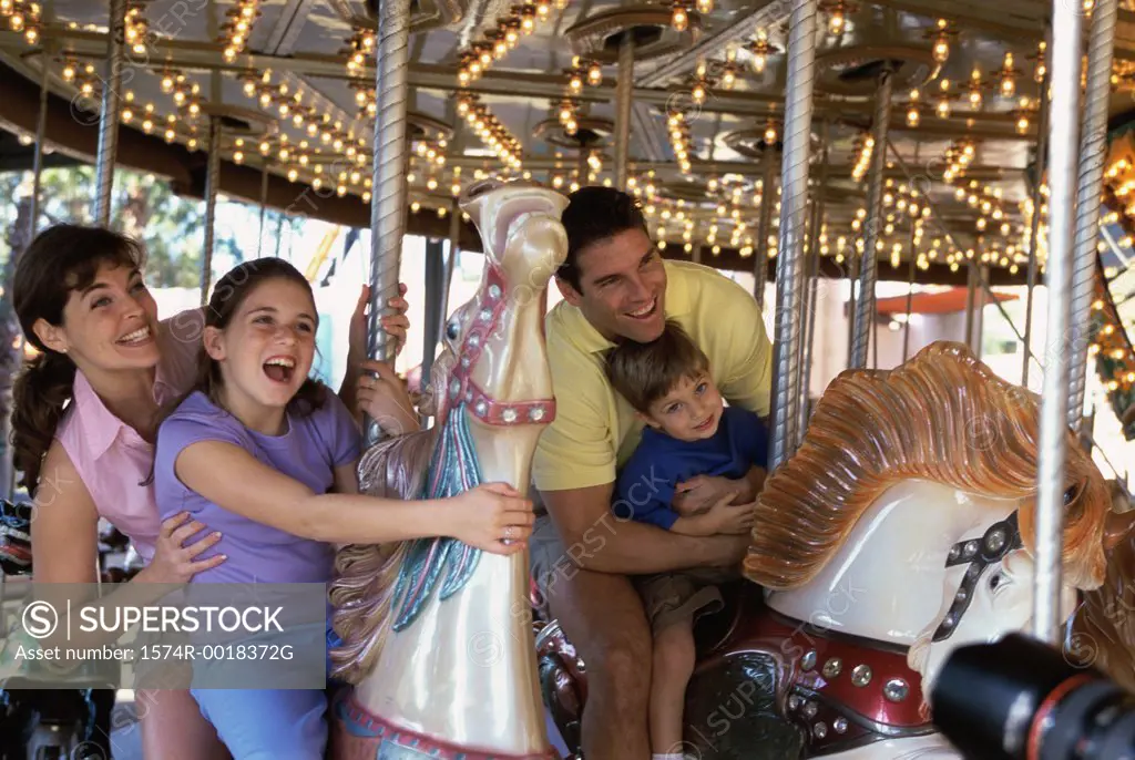 Parents with their son and daughter on a carousel