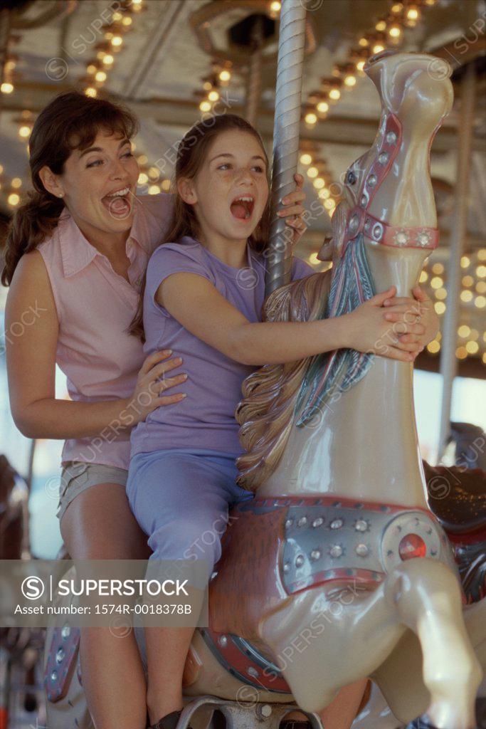 Stock Photo: 1574R-0018378B Mother and daughter on a carousel