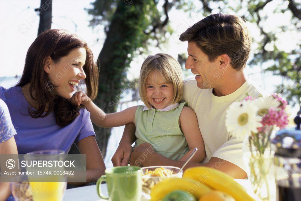 Stock Photo: 1574R-0018432 Parents sitting with their daughter and smiling