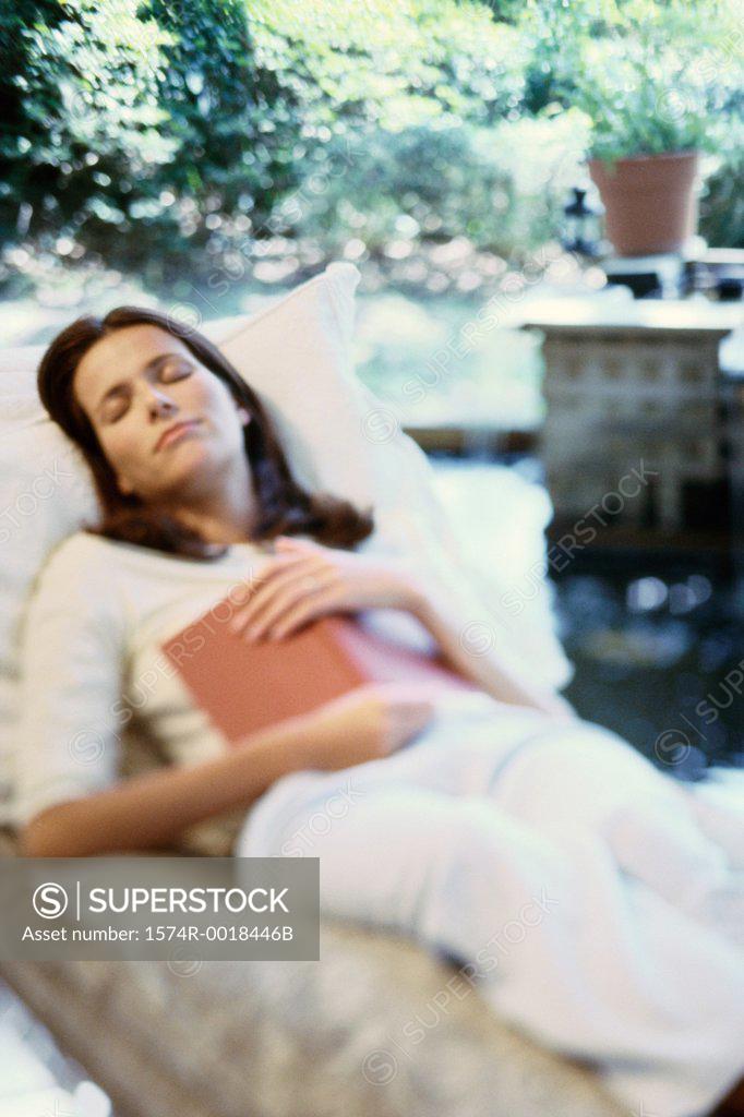 Stock Photo: 1574R-0018446B Young woman asleep with a book on her chest