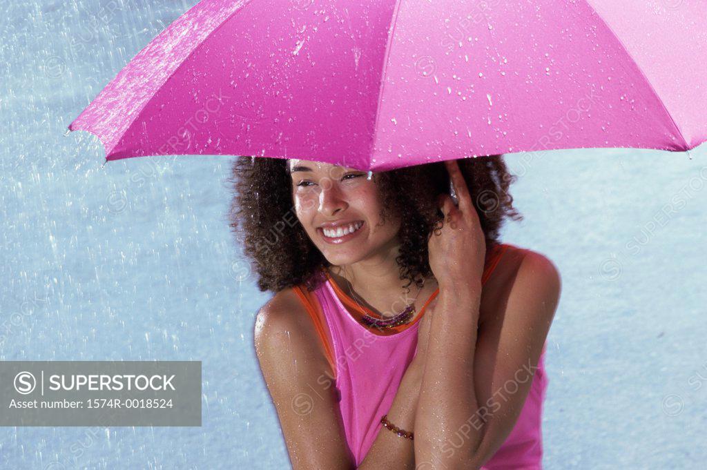 Stock Photo: 1574R-0018524 Young woman holding an umbrella in the rain