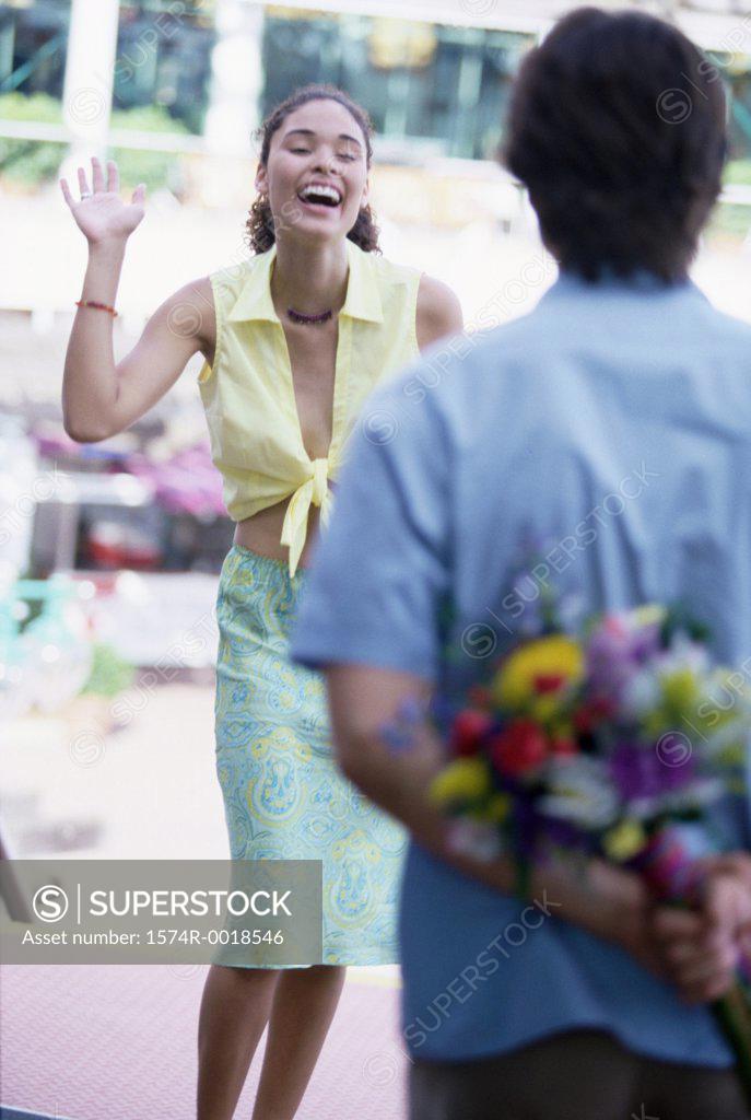 Stock Photo: 1574R-0018546 Rear view of a young man hiding a bouquet behind his back