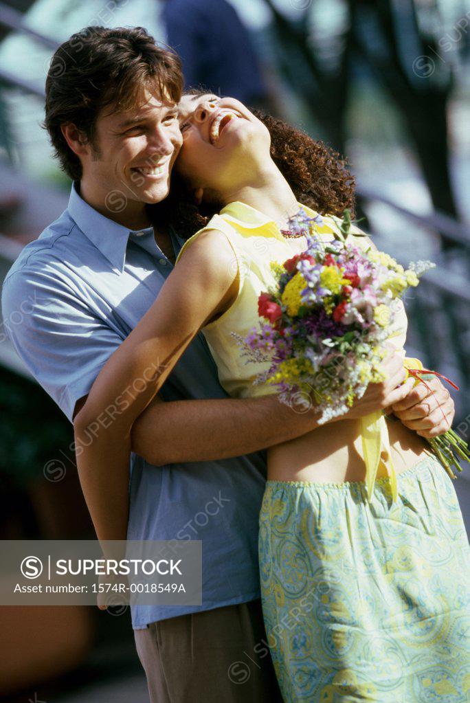 Stock Photo: 1574R-0018549A Teenage boy embracing a teenage girl from behind