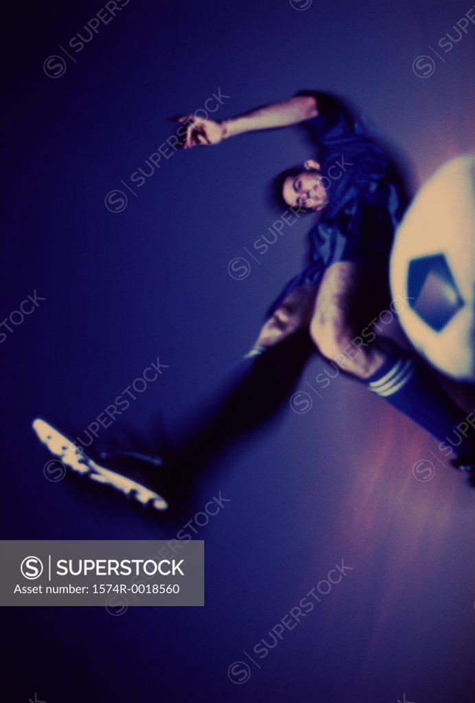 Stock Photo: 1574R-0018560 Low angle view of a soccer player kicking a soccer ball