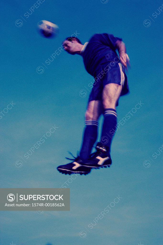 Stock Photo: 1574R-0018562A Low angle view of a soccer player in mid-air hitting a soccer ball with his head