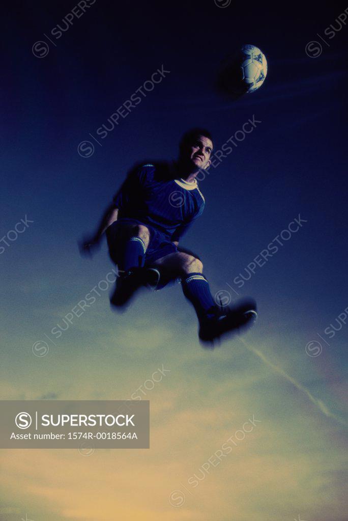 Stock Photo: 1574R-0018564A Low angle view of a soccer player in mid-air hitting a soccer ball with his head