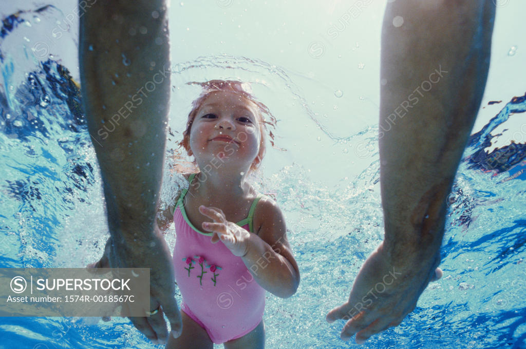 Stock Photo: 1574R-0018567C Close-up of father's hands reaching out to his daughter underwater