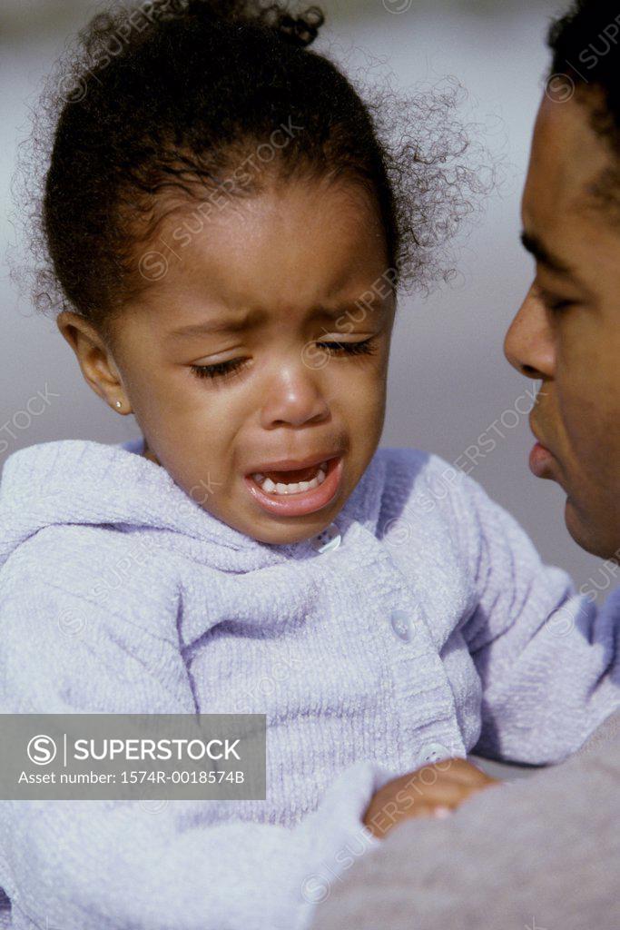 Stock Photo: 1574R-0018574B Close-up of a daughter crying in her father's arms
