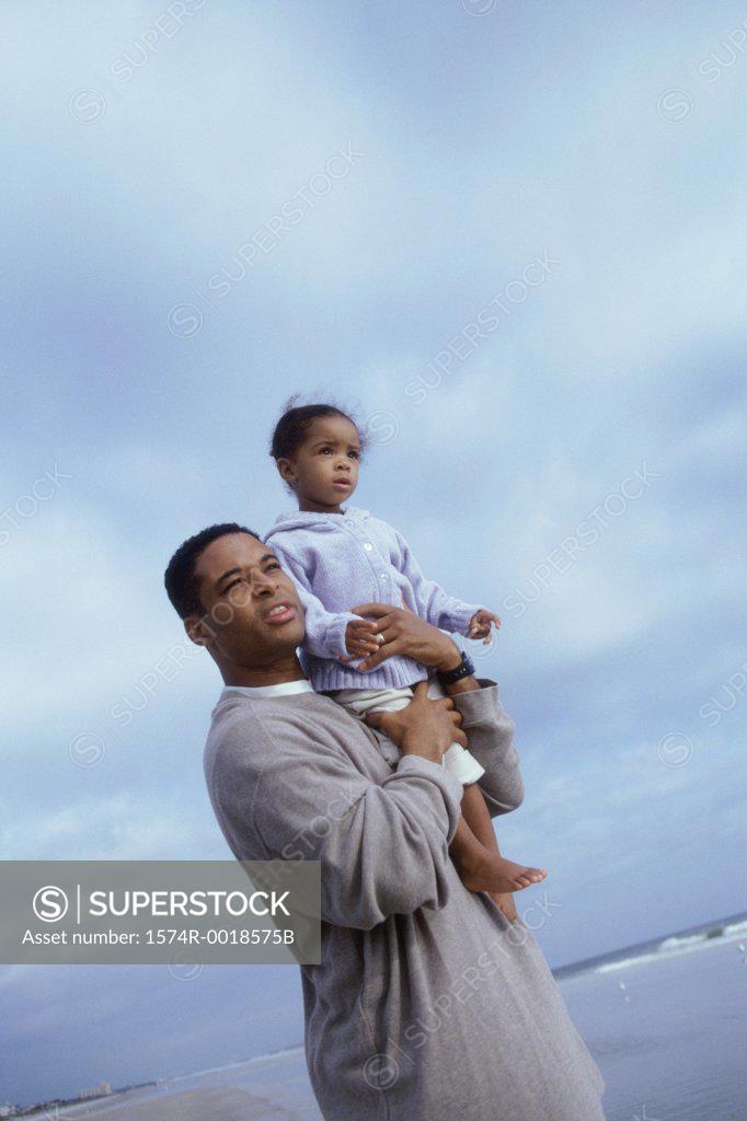 Stock Photo: 1574R-0018575B Side profile of a father carrying his daughter on his shoulders