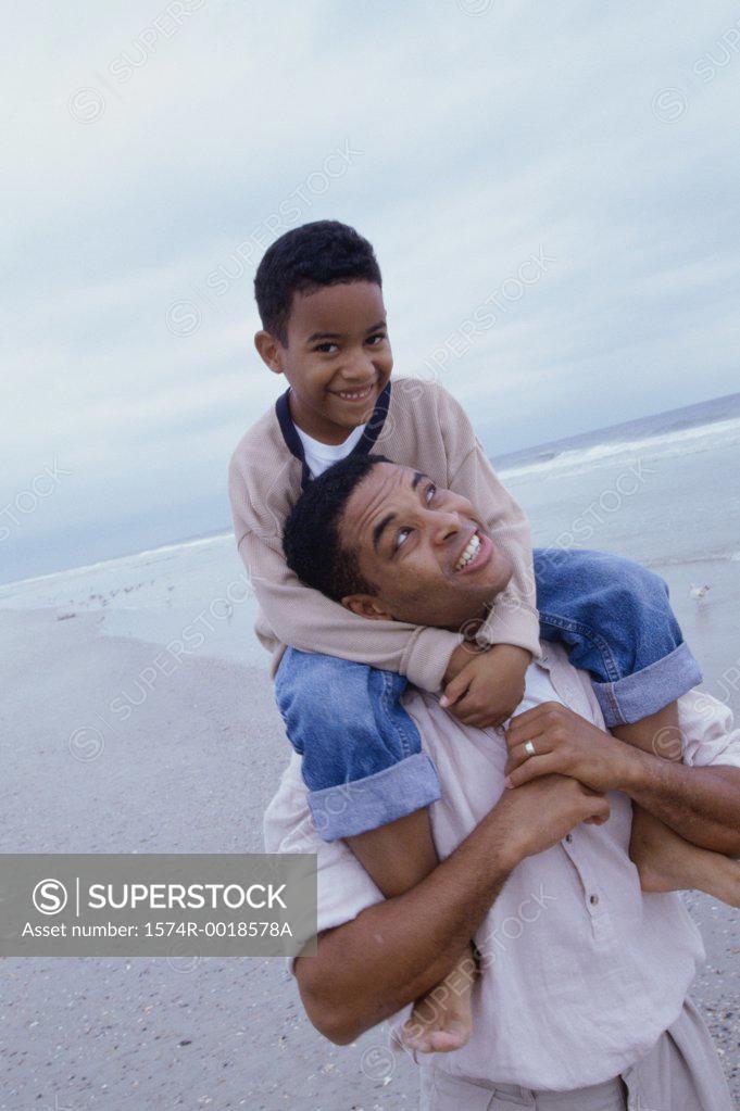 Stock Photo: 1574R-0018578A Close-up of a father carrying his son on his shoulders on the beach