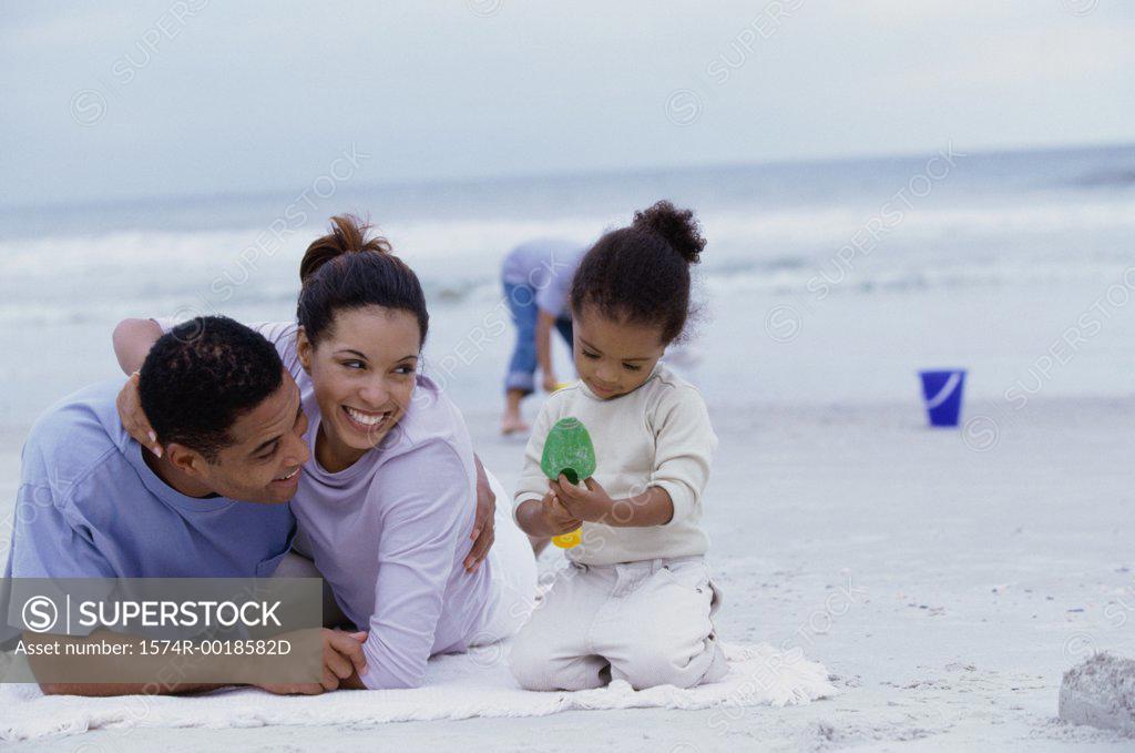 Stock Photo: 1574R-0018582D Parents playing with their daughter and son on the beach