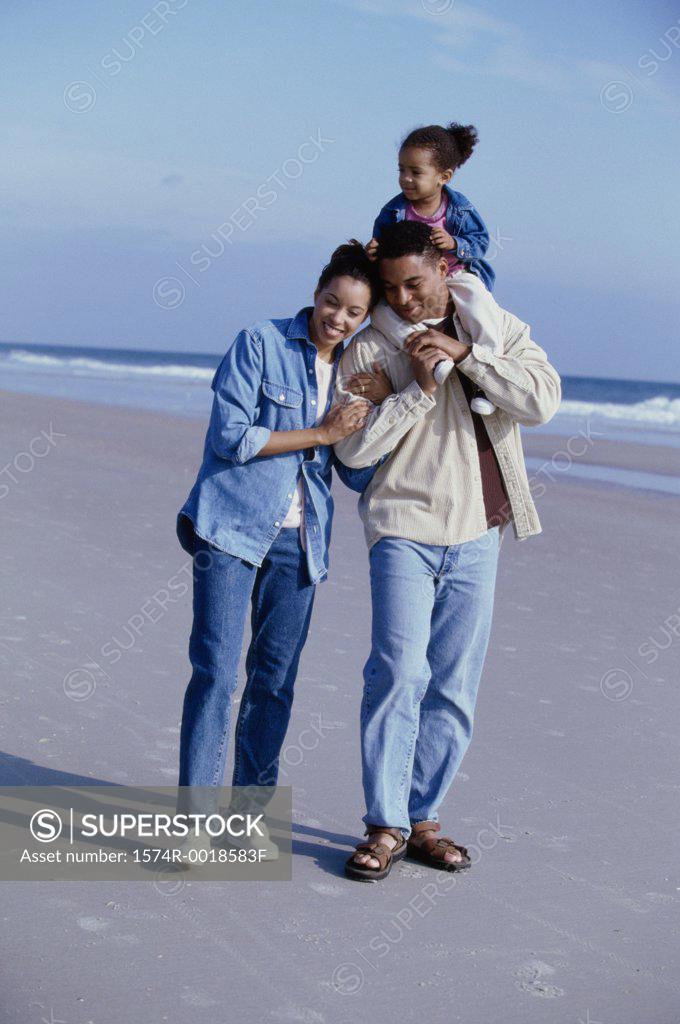 Stock Photo: 1574R-0018583F Parents smiling with their daughter on the beach