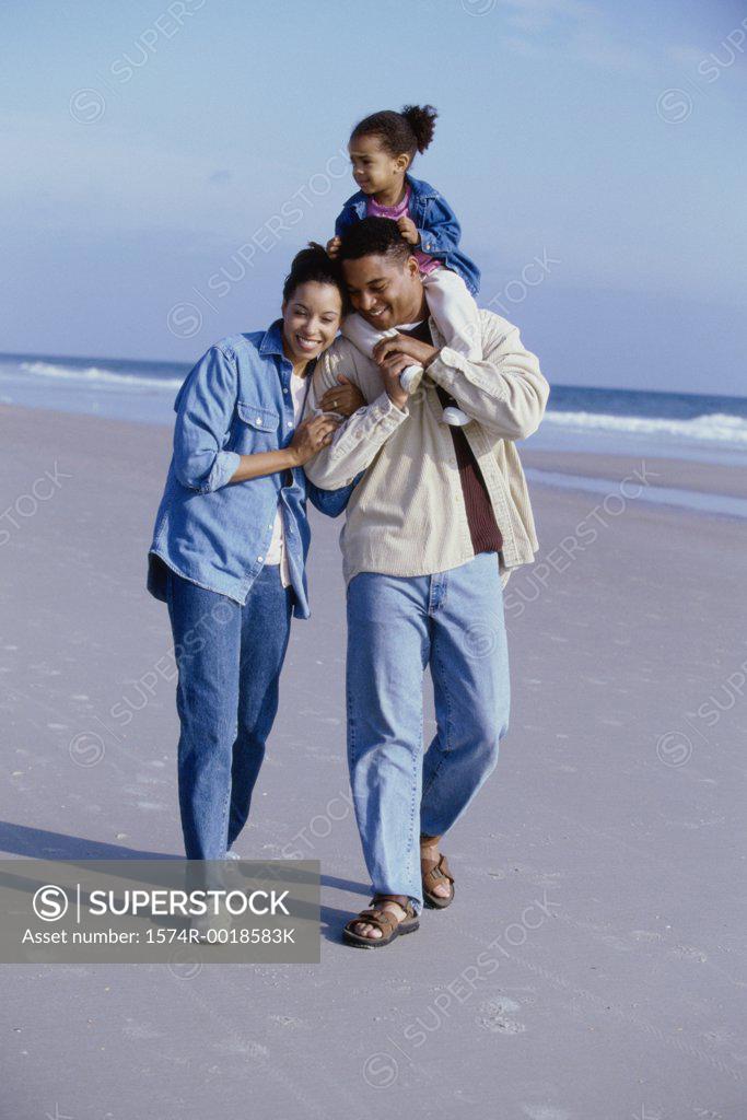 Stock Photo: 1574R-0018583K Parents smiling with their daughter on the beach