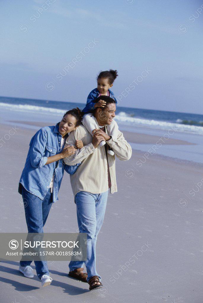Stock Photo: 1574R-0018583M Parents smiling with their daughter on the beach