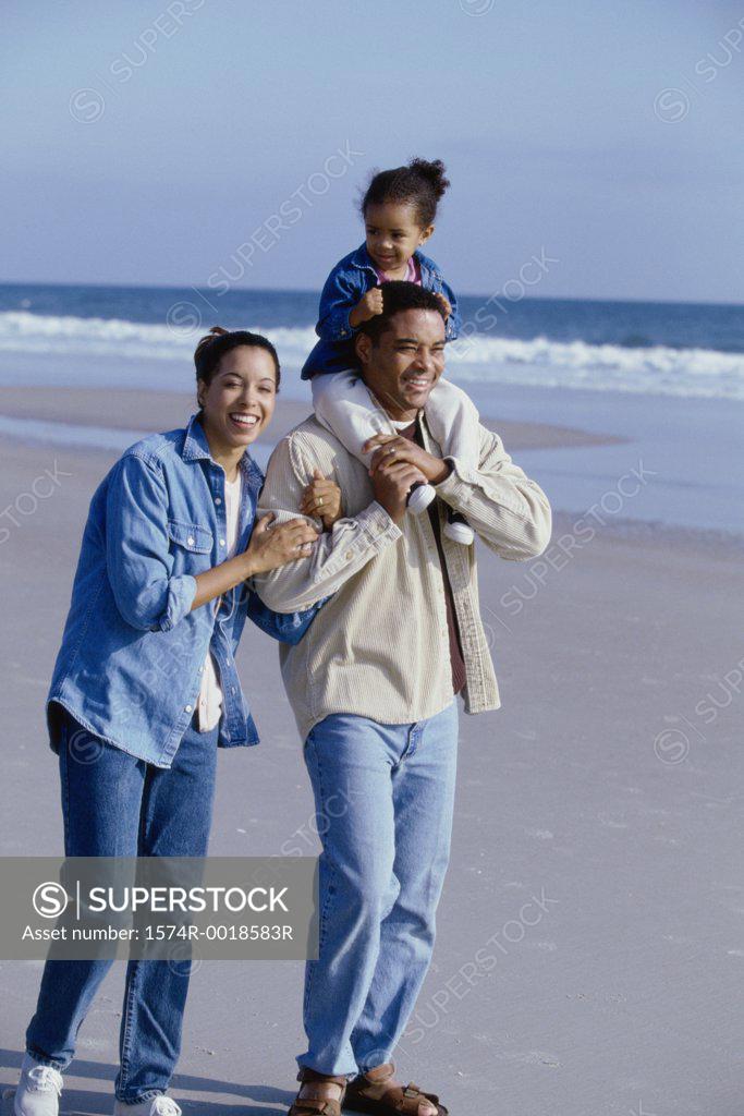 Stock Photo: 1574R-0018583R Parents smiling with their daughter on the beach